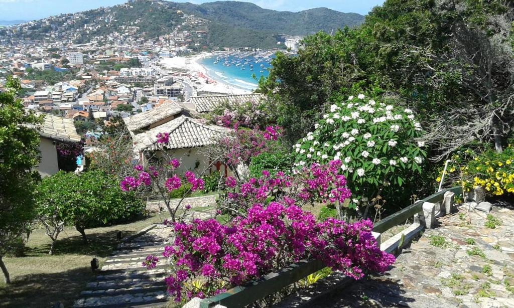 阿拉亚尔-杜卡布Casa Pontal do Atalaia的享有紫色和白色花卉海滩的景色