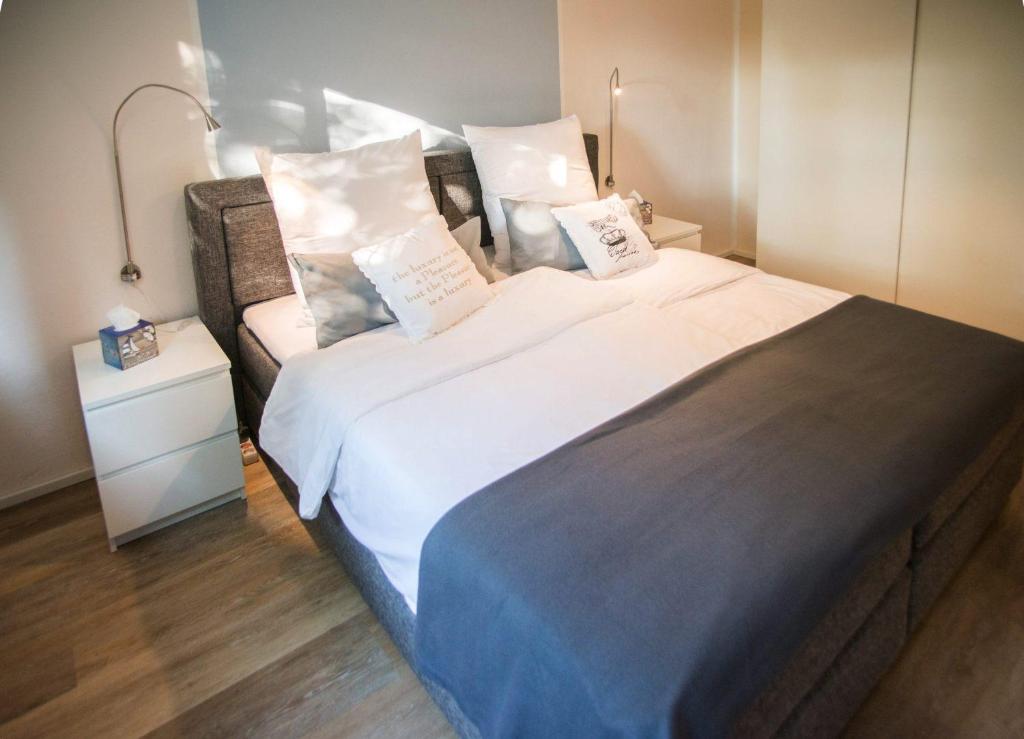 巴特皮尔蒙特Ferienwohnung First Bismarck的卧室配有一张带白色床单和枕头的大床。