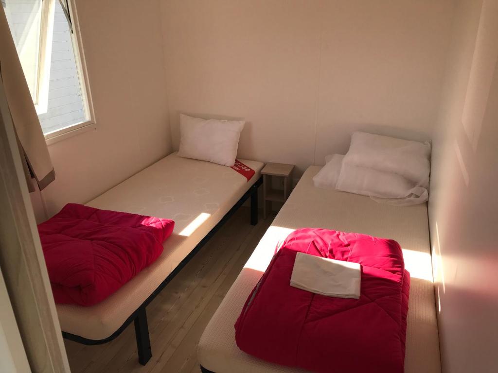 利托Domaine的小客房内的两张床,配有红色床单