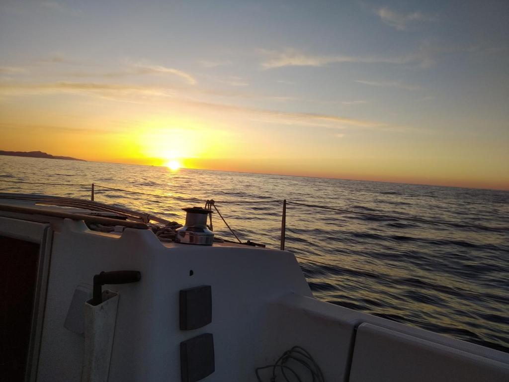 扎马亚Inolvidable experiencia en un velero de 11 metros!的海上的船,背面是日落