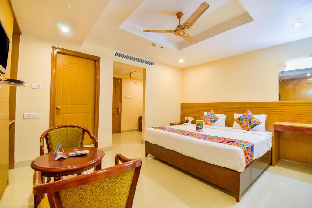 海得拉巴FabExpress Deccan Heritage Abids的一间卧室设有一张床铺、一张桌子和天花板