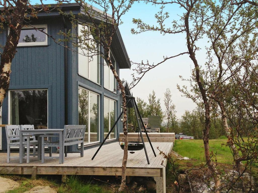 莱帕乔德6 person holiday home in Kvalsund的门廊,房子内有两把椅子和秋千