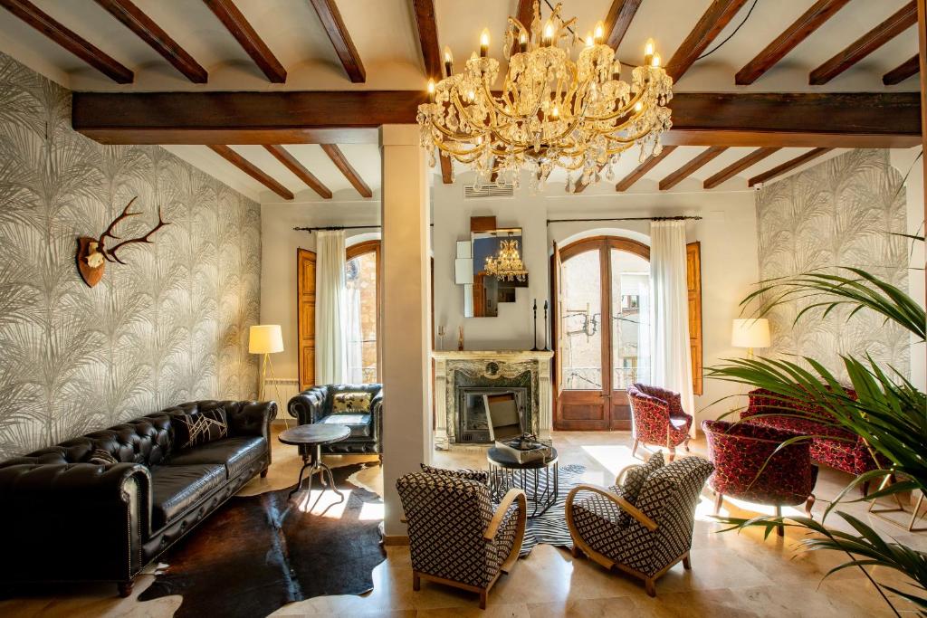 科尔努德利亚El Palauet del Priorat的客厅配有沙发、椅子和吊灯