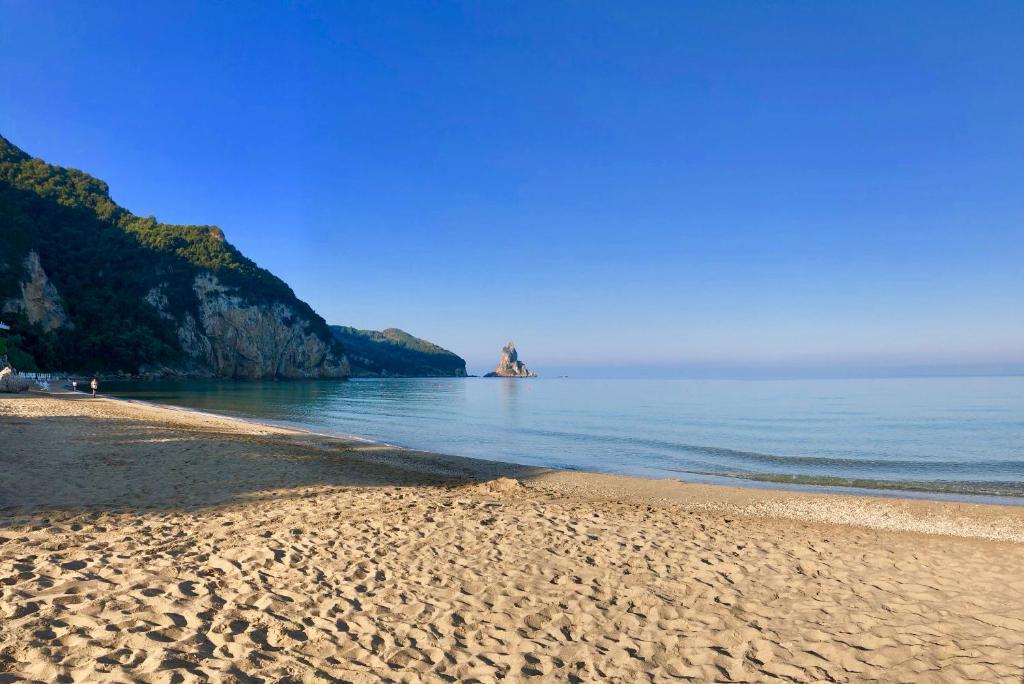 阿齐欧斯·贡多斯Sebastian's - Agios Gordios Beach的沙滩上,水里有岩石