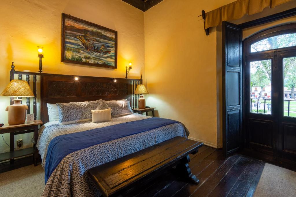 帕茨库卡罗伊图尔韦大厦酒店的一间卧室配有一张床和一张木凳