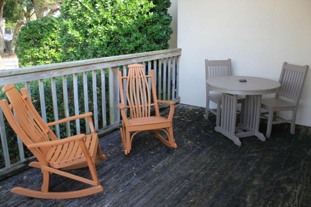 圣奥古斯丁Inn at Camachee Harbor Deluxe 19的门廊配有两把椅子、一张桌子和一张桌子