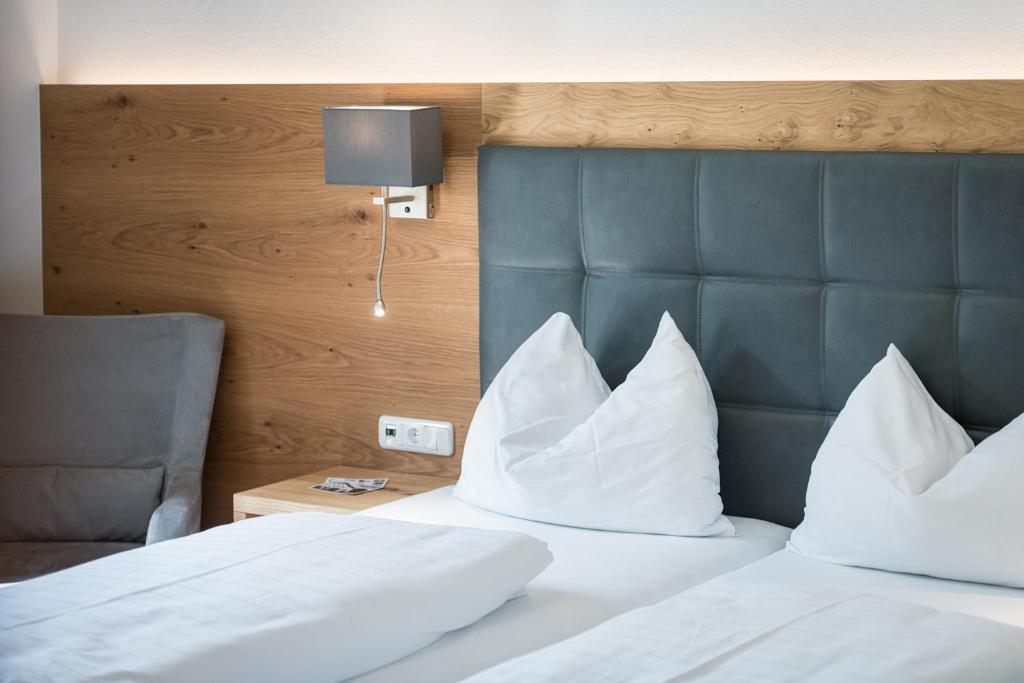 PillHotel Plankenhof B&B的一间卧室配有带白色枕头的床和床头板