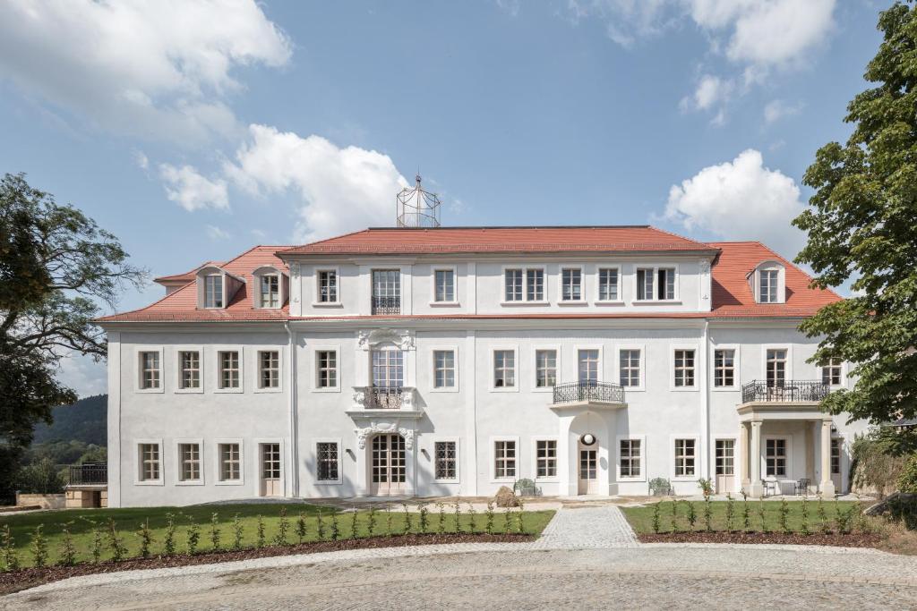 巴特尚道Schloss Prossen的一座大型白色豪宅,设有红色屋顶