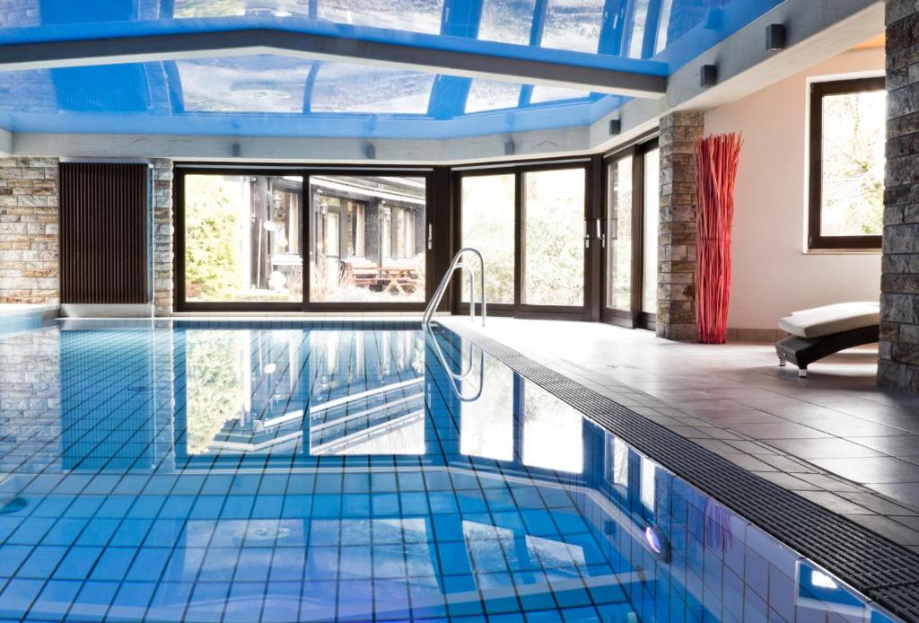 安斯巴赫凯斯巴克穆尔酒店的游泳池设有蓝色瓷砖地板和窗户