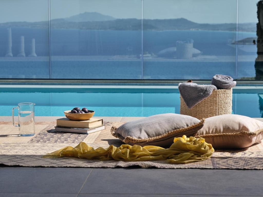 KoríthionThea lux natur villa的游泳池畔桌子上的毯子和枕头