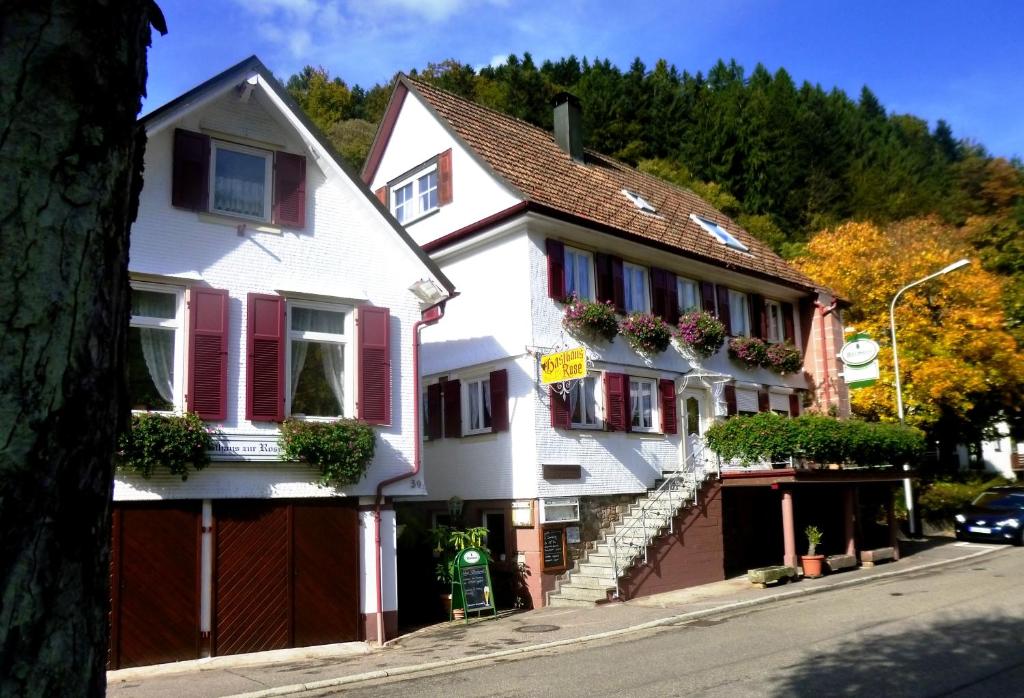 巴特彼得斯塔尔-格里斯巴赫Pension Zur Rose的街上有红色百叶窗的白色房子
