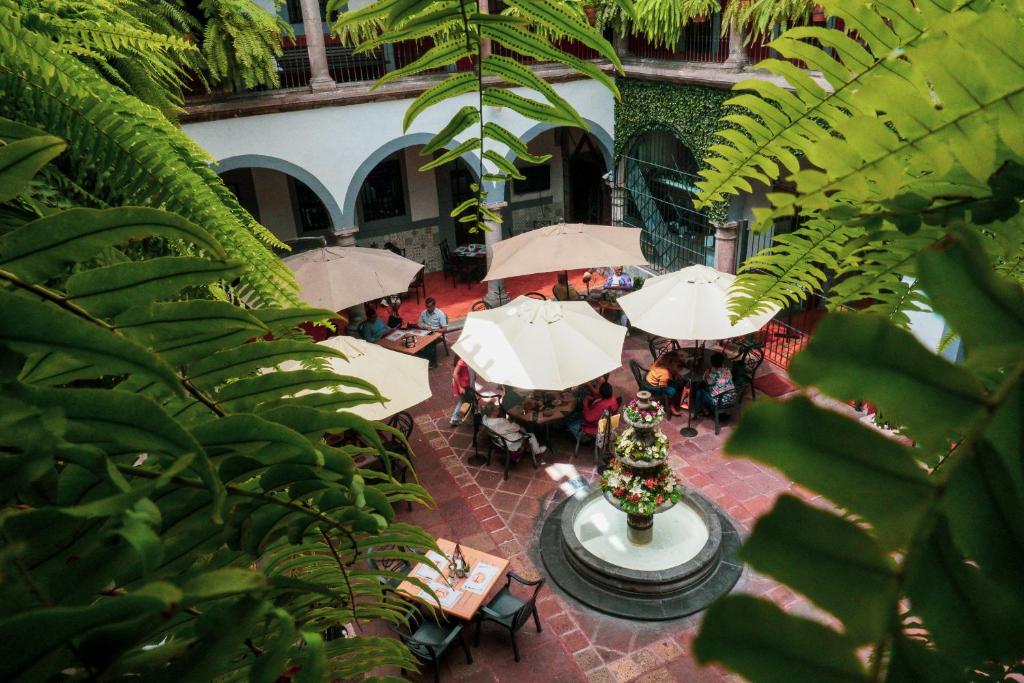 克雷塔罗希达尔戈酒店的享有庭院的顶部景色,配有桌子和遮阳伞