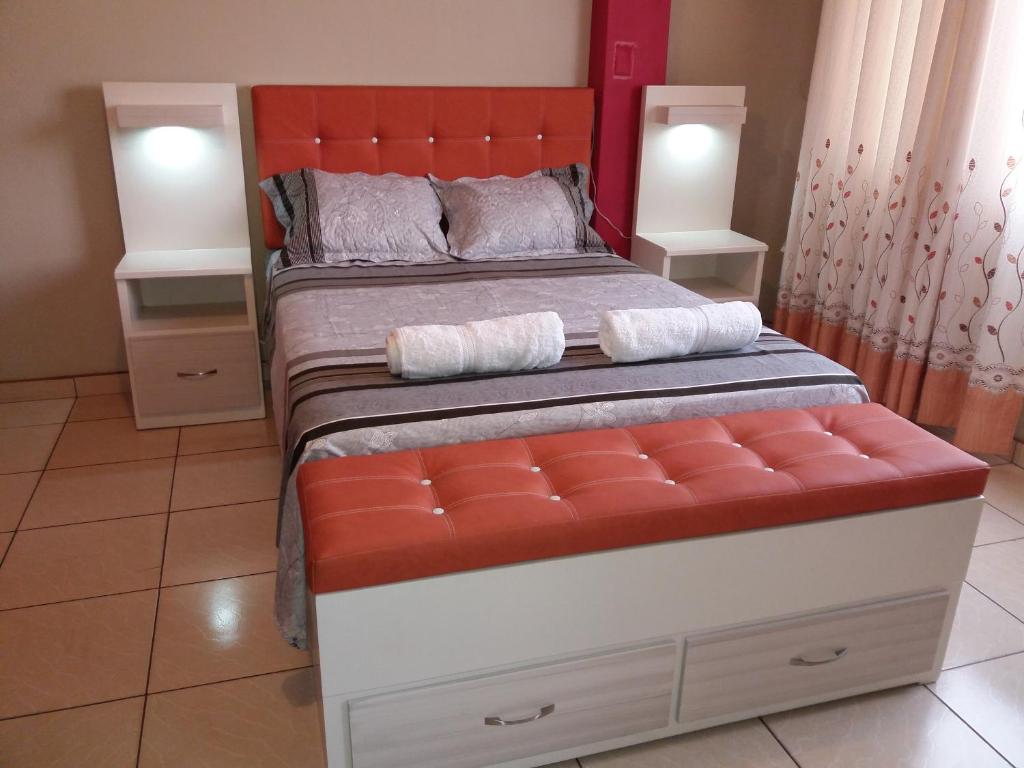利马La Quilla House的一间卧室配有一张带橙色床头板的大床