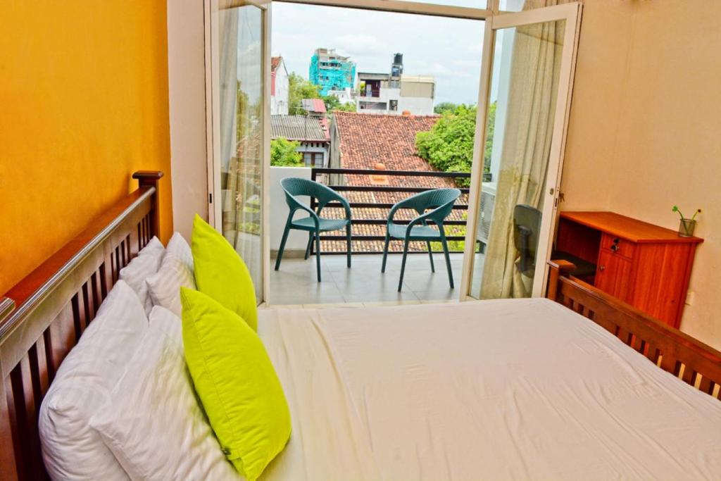 拉夏吉里雅Furnished apartment at Colombo suburbs Nawala的一间卧室配有一张床,阳台配有椅子