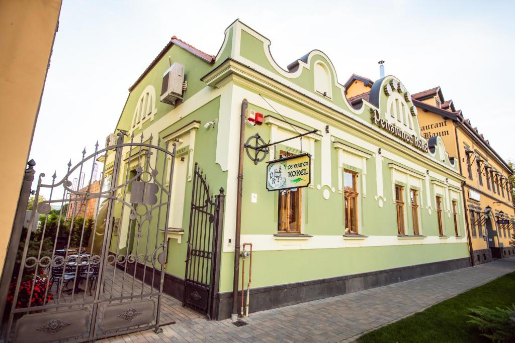 DumbrăveniPension Kokel的绿色和白色的建筑,设有大门