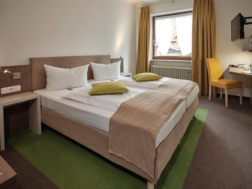 塞费塔尔祖尔林德酒店的一间卧室配有一张大床和一张书桌