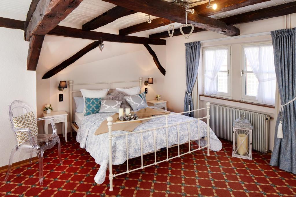 维桑堡Historisches Gästehaus Au Faucon的一间卧室配有一张床,铺有红色地毯