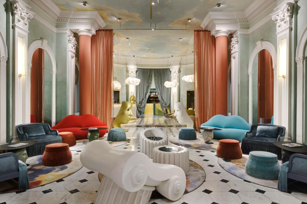 罗马罗马里昂宫酒店的大堂,大楼里摆放着五颜六色的桌椅