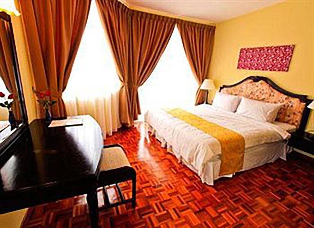 迪沙鲁D'Vista Apartments in Lotus Desaru Beach Resort的配有一张床和一张书桌的酒店客房