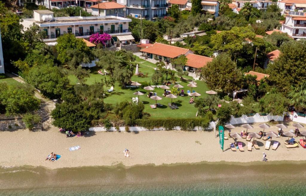 梅加利阿莫斯昂吉里克海滩酒店的一群人坐在海滩上靠近水面