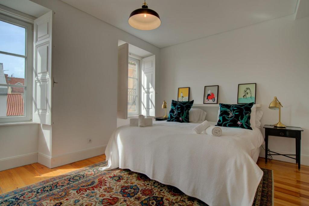 里斯本Tracey & Neill's Place in Principe Real的白色的卧室设有一张大床和一个大窗户