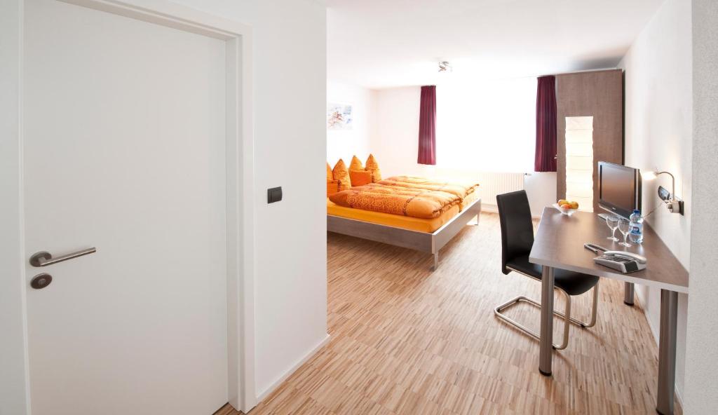 菲尔德施塔特梅林酒店的卧室配有床、书桌和门