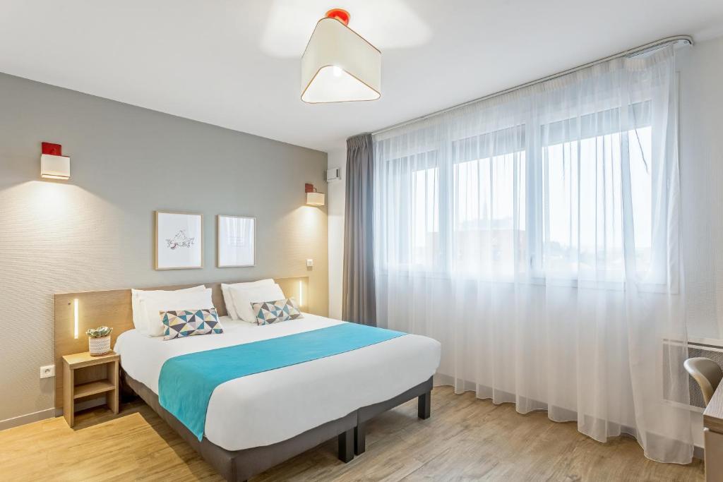 亚眠Appart'City Confort Amiens Gare的一间卧室设有一张大床和一个窗户。