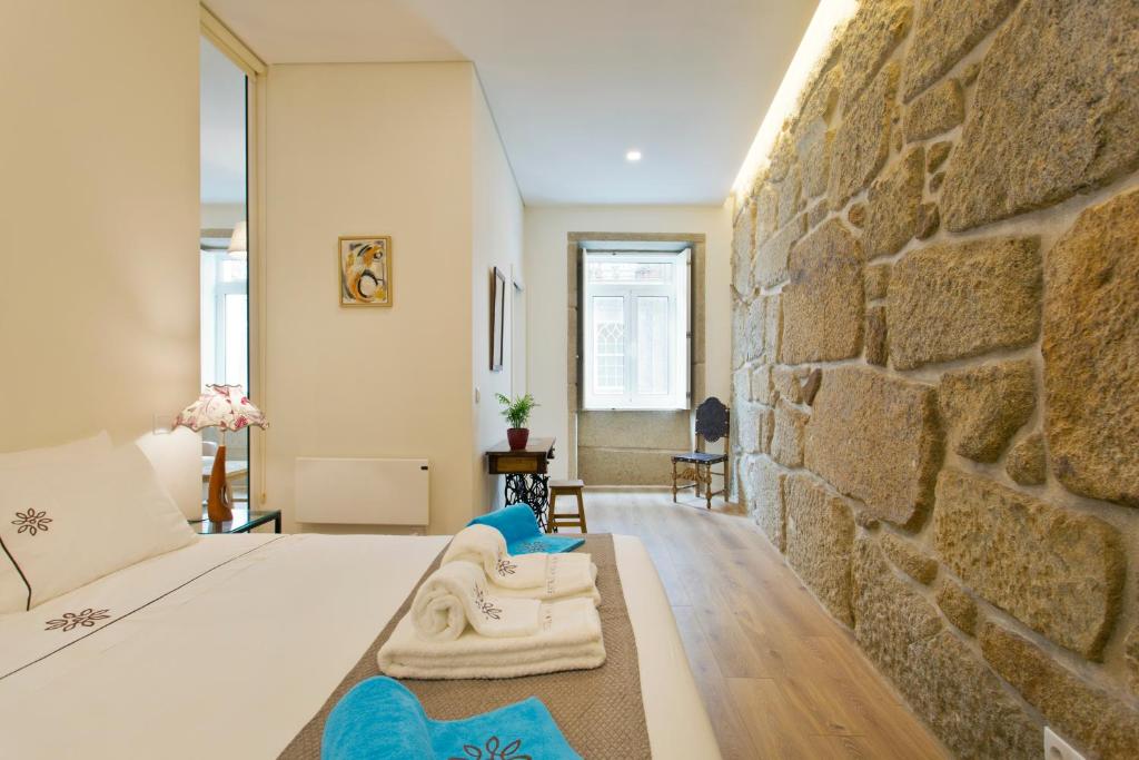 加亚新城Estrela de Gaia Apartments的一间卧室设有石墙和一张床