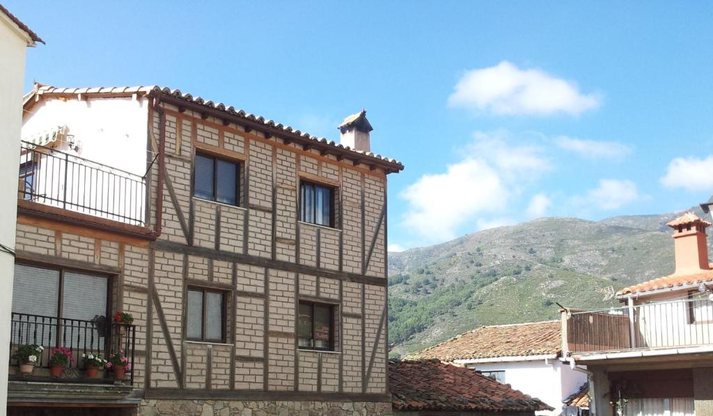 吉霍－德圣巴巴拉Casa Rural Santa Bárbara的一座带窗户的建筑,背景是一座山