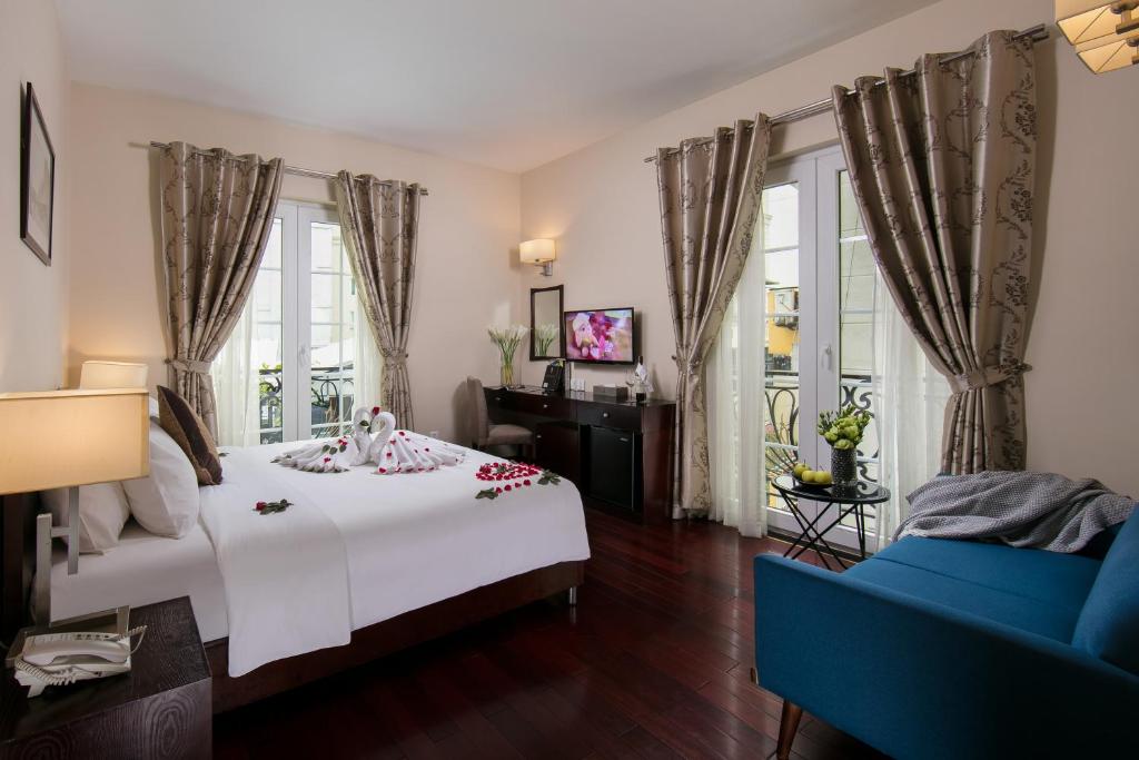 河内森莱酒店的卧室配有白色的床和蓝色的沙发