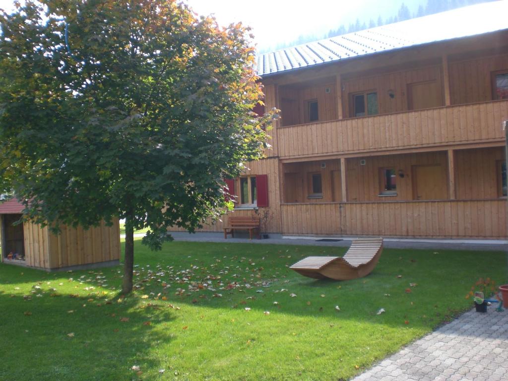 瓦尔德阿尔贝格Gästehaus zum Bären的一座建筑前的绿色庭院,设有长凳