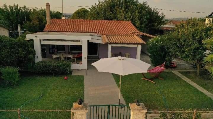 卡塔科隆Villa Evdokia的房子院子的白色雨伞