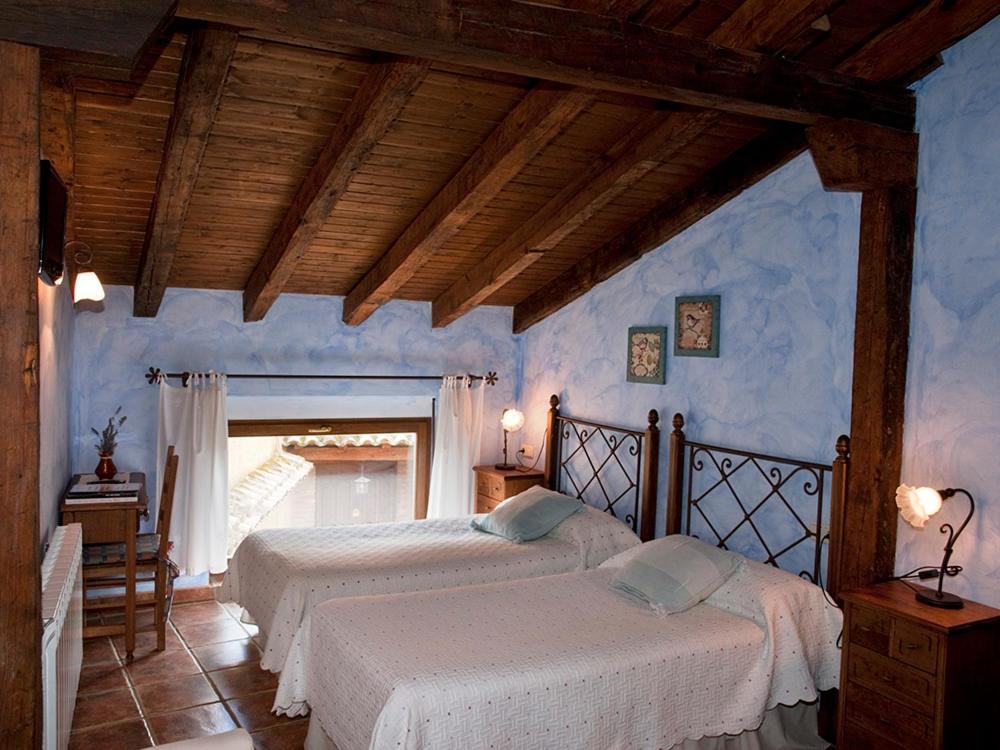 Villalón de CamposCasa Rural El Encuentro的卧室设有两张床铺和蓝色的墙壁