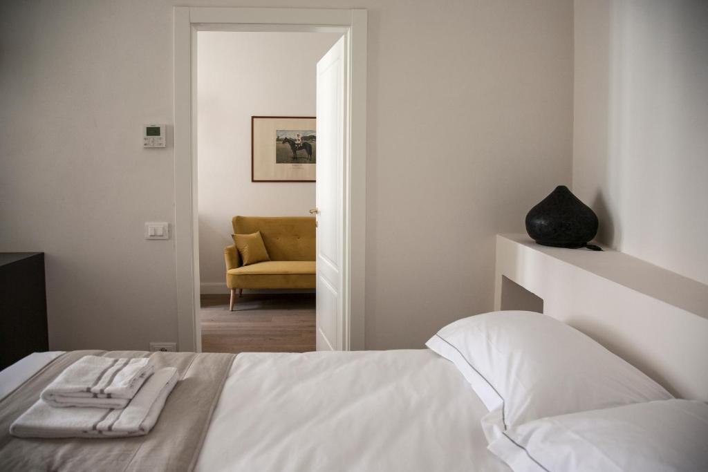 佛罗伦萨Pietrapiana34 Boutique Apartments的卧室配有白色的床和黄色的沙发