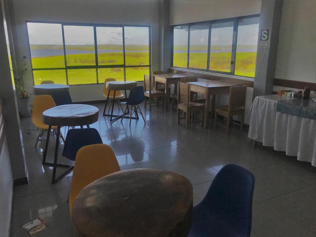 伊基托斯Amazon Dream Hostel with AC and Starlink的用餐室设有桌椅和窗户。