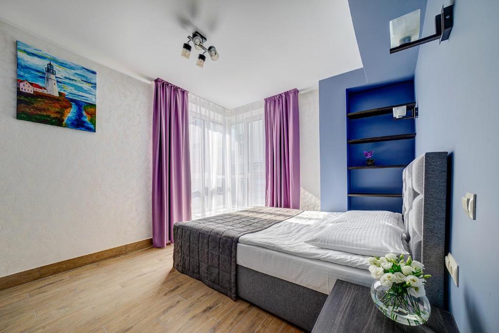 特维尔Hotel Luidor的一间卧室配有一张床和一个带紫色窗帘的窗户
