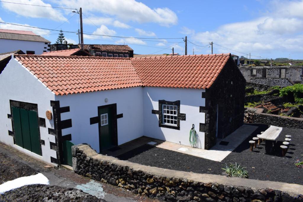 马达莱纳Casinha da Avó Jerónima RRAL 1519的一间白色的小房子,有红色的屋顶