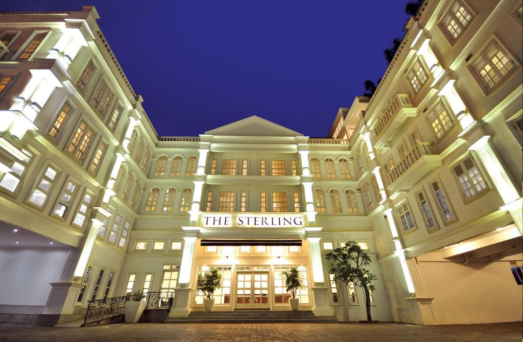 马六甲马六甲斯特林精品酒店的一座大建筑,晚上闪亮着光芒