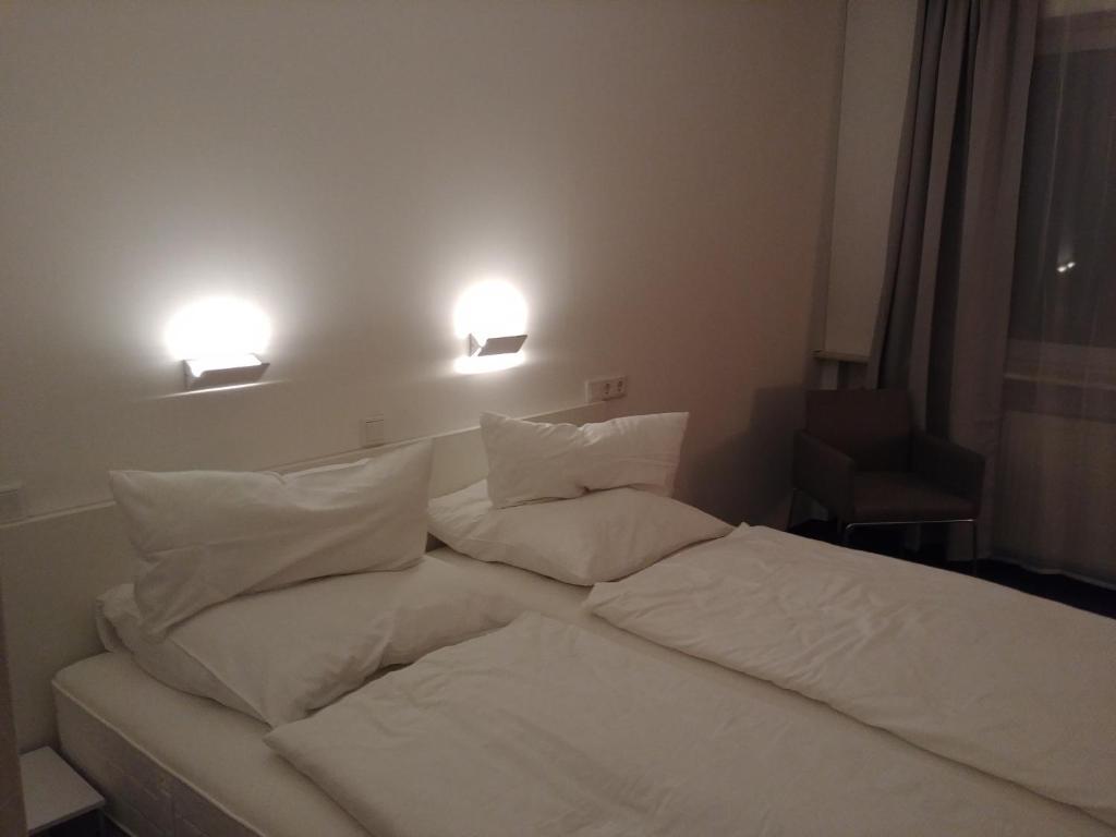 Niederfüllbach全景酒店的一张带白色床单和枕头的床
