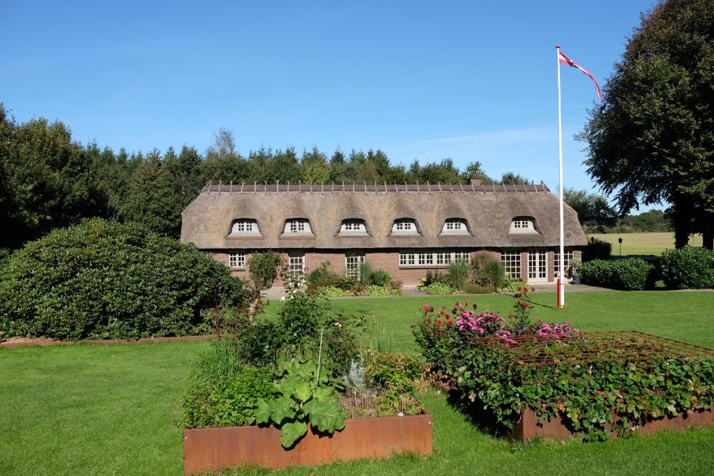 比伦德比隆客房旅馆的一座带茅草屋顶和一些鲜花的老房子