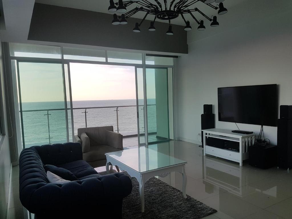 米里Bay Resort Condominium, 7, Beach-front Sea view, 6-8 PAX的带沙发、电视和桌子的客厅