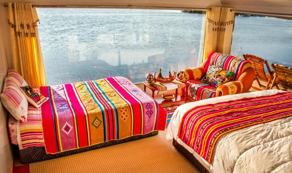 普诺Luz del Titicaca Lodge的一间卧室设有两张床和窗户。