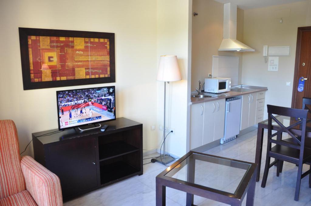 塞维利亚卢克瑟维亚宫公寓的客厅配有电视和桌椅
