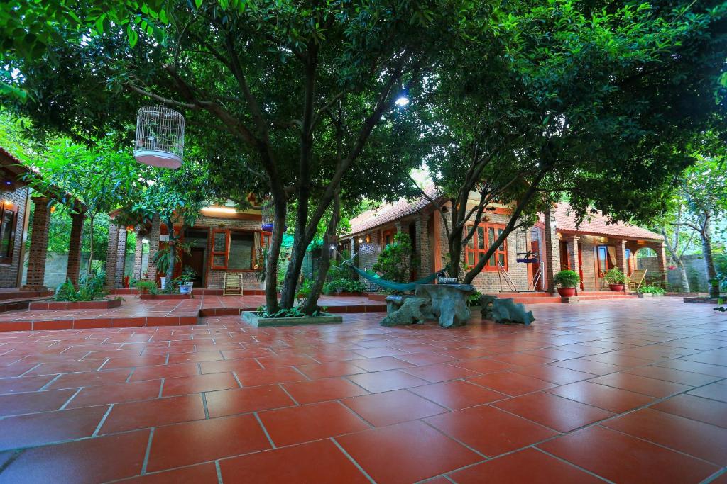 宁平塔姆家庭民宿的一座绿树成荫的公园,铺有红色瓷砖地板