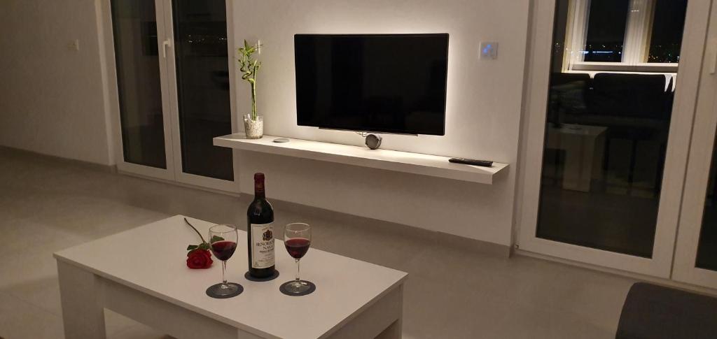 格拉纳达ecoSmart Apartments Granada的客厅配有带酒杯的桌子和电视