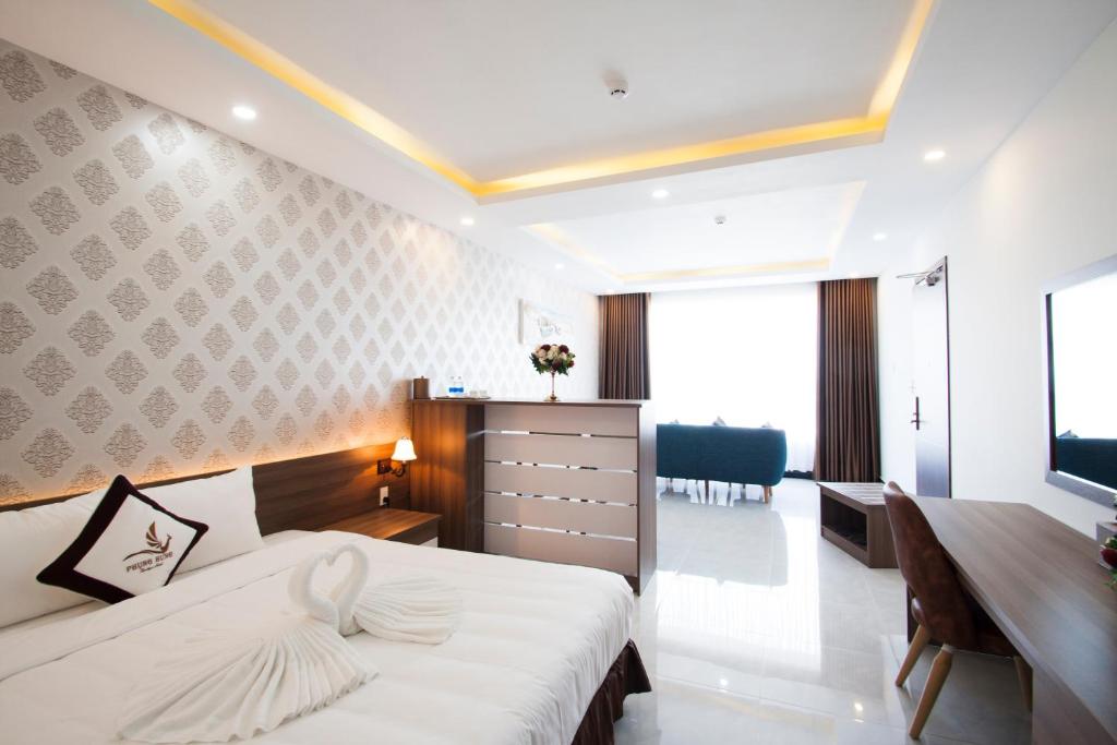 富国Phung Hung Boutique Hotel的酒店客房配有一张床、一张书桌和一张书桌。