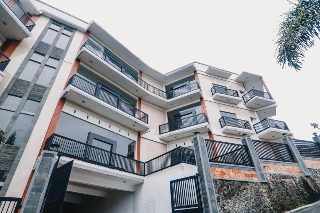 玛琅RedDoorz near Taman Rekreasi Selecta的公寓大楼设有阳台和棕榈树