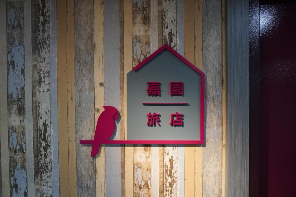 台南台南嘉园旅店的墙上的标志,上面有红鸟