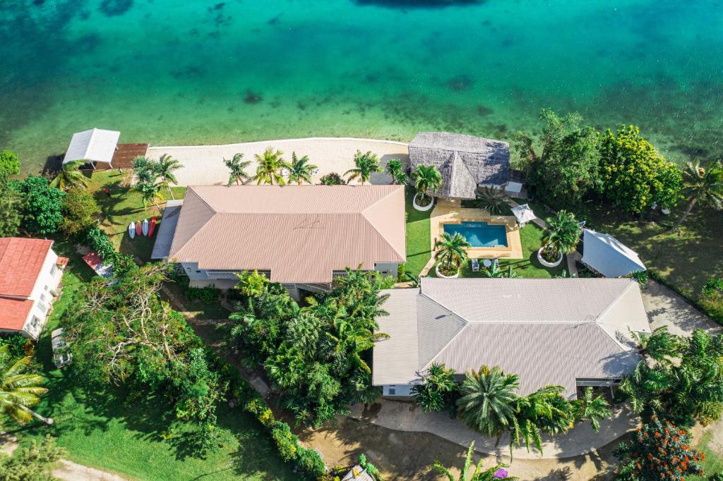 维拉港热带泻湖公寓式酒店的享有带游泳池和大海的房屋的空中景致