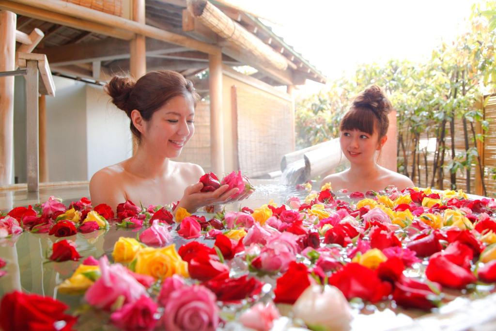 琴平町琴平町樱花之所大酒店的两个女人站在一张花桌旁